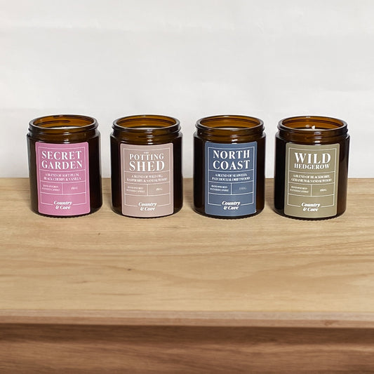 A set of 4 scented candles on a table top - handmade by Country & Cove UK